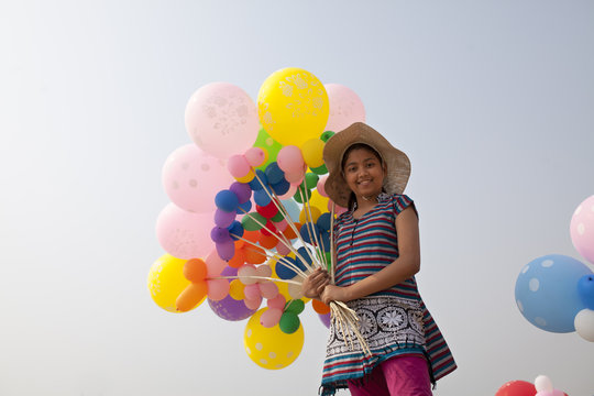 Teenage girl with colorful balloons in hand