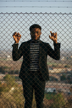 African man behind an iron grid