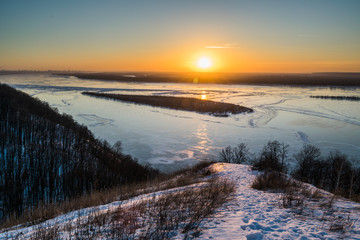 Panoramic view on frozen Volga river in winter during sunset from hill near Samara city