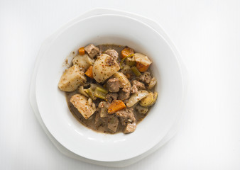 a bowl of beef stew with potatoes, carrots, celery, mushrooms and onions is shown