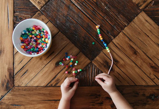 Preschool girl playing with beads.