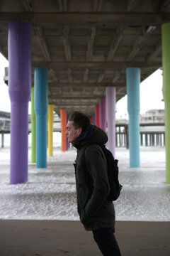 Young man in the storm on the beach