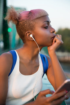 Young woman listening to music from her headphones