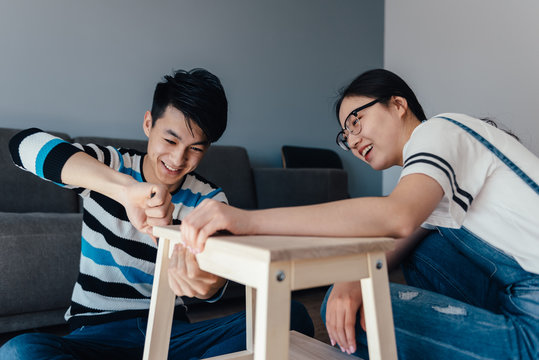 Young couple assembling flat-pack furniture