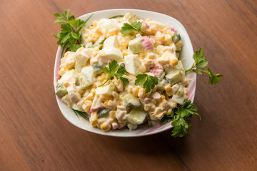 Salad with crab sticks, sweet corn, cucumber, eggs and mayonnaise