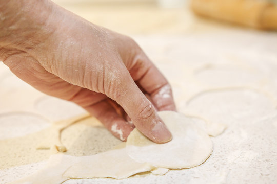 woman is making dough closeup. Hands on the table with flour and dough macro