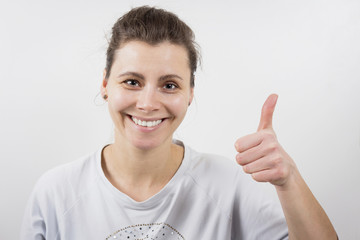Beautiful smiling girl with thumb up. Portrait of attractive woman with smile on her face. Caucasian happy girl on white background. Like, liking, liked.