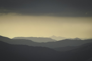 Fototapeta na wymiar Abstract monochrome mountain landscape in retro photo tonality. Layers of mountain and haze in the hills. 