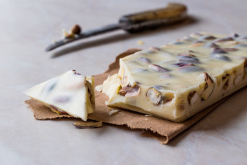 White Chocolate Piece with Pistachio on Marble Surface.