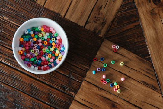 Colorful beads on wooden table.