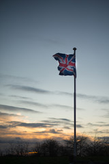 British flag fluttering against sunset