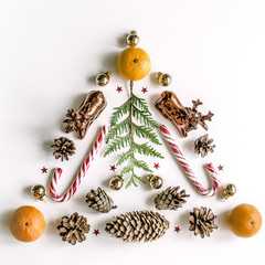 New Year composition with mandarins, tuya, cones and New Year balls. Everything is arranged in the form of a Christmas tree.