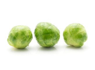 Boiled Brussels sprout isolated on white background three whole heads in row.