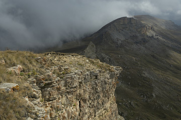 The view from the edge of the mountain plateau and the clouds in the valley. North Caucasus. Plateau Bermamyt.