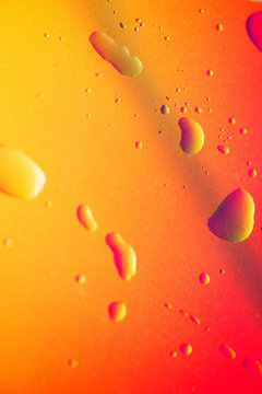 Macro shot of drops on orange laptop sceen