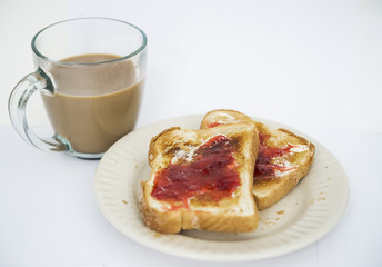 Toasted white bread is shown with jam and margarine next to a cup of coffee