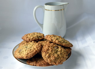 Homemade golden oatmeal cookies with raisins and white milk jug