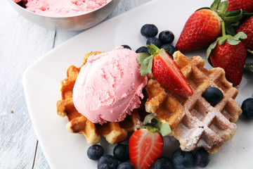 Plate of belgian waffles with strawberry ice cream, and fresh strawberries