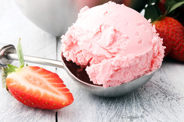 Delicious strawberry ice cream scoop with fresh strawberries on wooden background