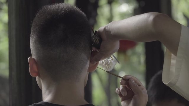 Man recieves a customary Chengdu ear cleaning