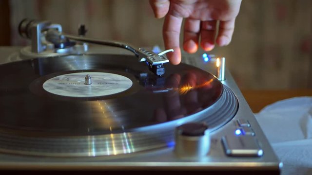 close up of hand changing the track on the turntable record