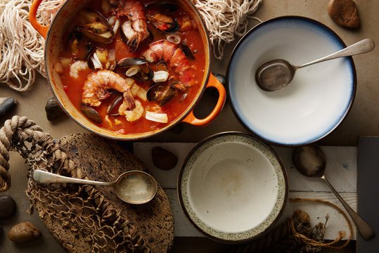 Seafood stew served in bowls in a rustic table setting.