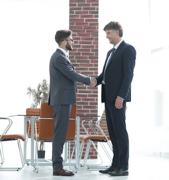 Two business people shake hands in the office