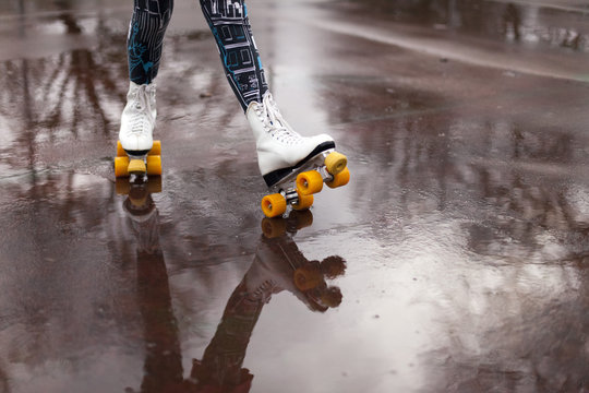 Roller skates in the rain with reflection in puddle