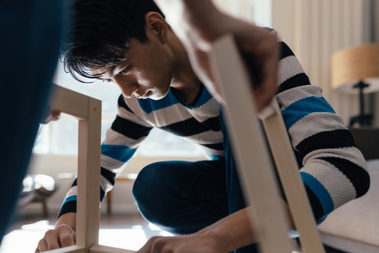 Young couple assembling flat-pack furniture
