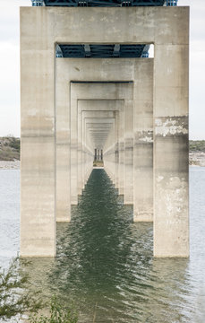 Photo of pillars under a bridge on a lake