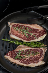 стейк из мраморного мяса с розмарином в сковородке - гриль 