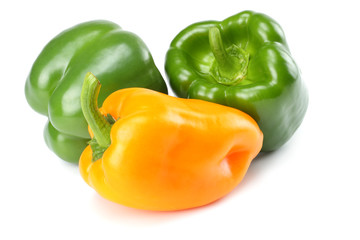 three green and yellow sweet bell peppers isolated on white background