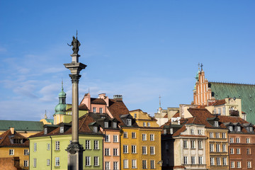 Colorful tenement houses and the Sigismund's Column  at the Castle Square in Warsaw, Poland. Picturesque old town under a clear blue sky.