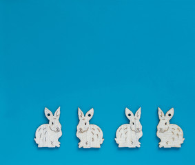 White esater bunnies lined up at the bottom of blue copyspace, facing opposite directions - easter background