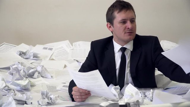 the man in the office drowning in paper