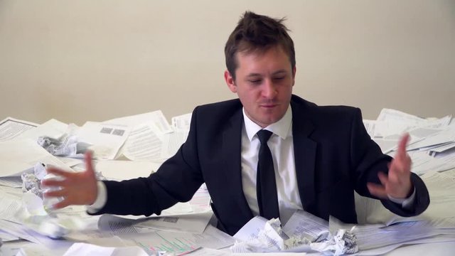 the man in the office drowning in paper