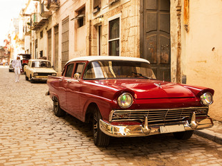 Red old and classical car in road of old Havana (Cuba)