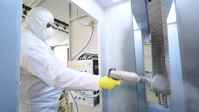 industrial metal coating. Man in protective suit, wearing a gas