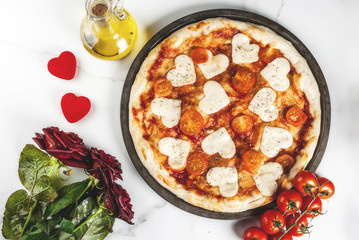 Valentine holiday food concept, pizza margarita with heart shaped cheese, white marble background, copy space top view, with roses