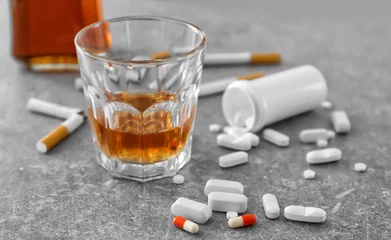Foto op Plexiglas Glas alcohol, sigaretten en drugs op tafel. Concept van slechte gewoonten © Africa Studio