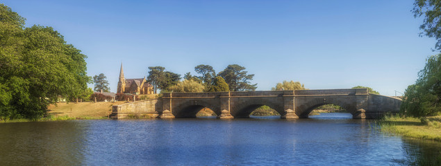 Convict built stone bridge over Ross river with church in background