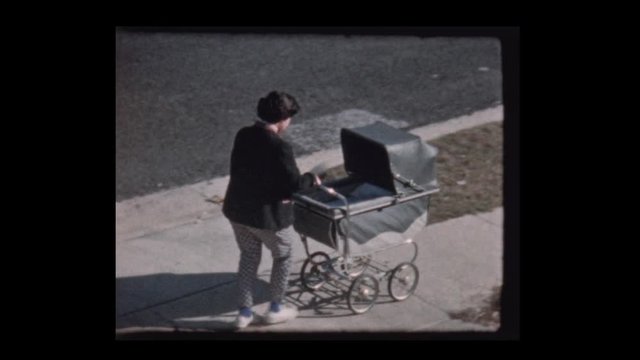 1959 Young girl pushes baby in vintage antique baby stroller