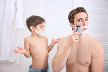 Father and his little son shaving in bathroom