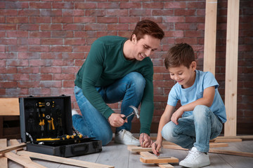Father and his little son with tools in workshop