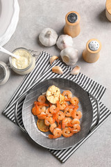 Dish with delicious fried shrimps and garlic on table