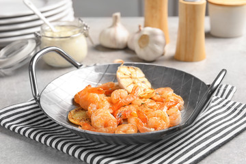 Dish with delicious fried shrimps and garlic on table