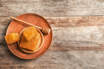 Plates with fresh honeycombs on wooden background
