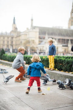 Family Feeding Pigeons in Historic London Square