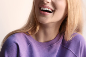 Smiling woman in violet sweatshirt on light background