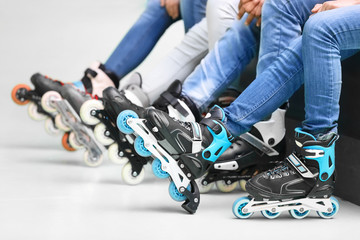 Group of people wearing roller skates on light background